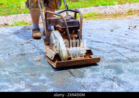 Während des Baus der Poolplattform verdichtet die manuelle Vibrationsmaschine Sand Stockfoto