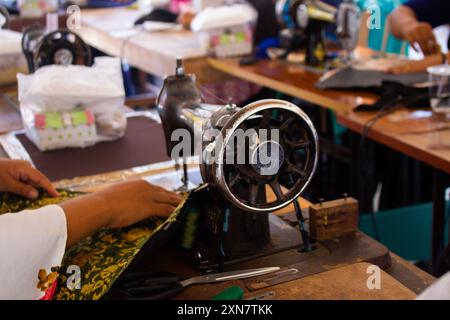 Reihe antiker Nähmaschinen auf einem Holztisch mit selektivem Fokus Stockfoto