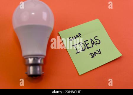 Eine gute Idee? Teilen Sie es! Eine Glühbirne und ein Hinweis fördern Brainstorming und Zusammenarbeit am Tag der Ideen tauschen. Stockfoto