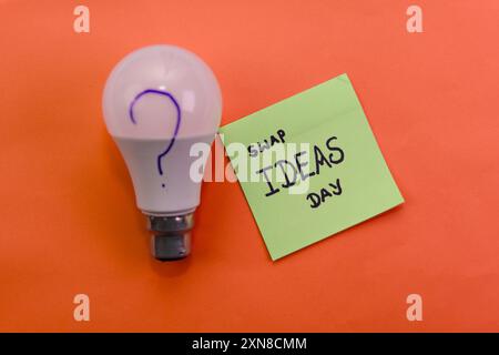 Glühbirne und Notiz mit „Swap Ideas Day“ inspirieren zu kreativer Zusammenarbeit und Innovation. Stockfoto