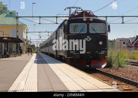 Hedemora, Schweden - 30. Juli 2024: SJ Intercity-Zug mit Elektrolokomotive der Baureihe RC6 1417 von Stockholm aus gezogen und erreicht den Bahnhof Hedemora. Stockfoto