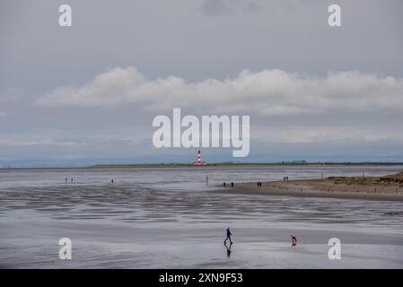 Versandzeichen für mehr als 100 Jahre. Südansicht des Leuchtturms von Westerheversand vom Strand von Sankt-Peter-Ording bei Ebbe aus gesehen. Erbaut 1906 in den Salzmärschen des Wattenmeers bei Husum, ist es ein historisches Wahrzeichen der deutschen Nordseeküste und eine beliebte Touristenattraktion. Es liegt auf einem flachen Gebäude, nur ein paar hundert Meter von der eigentlichen Wasserlinie entfernt. Stockfoto