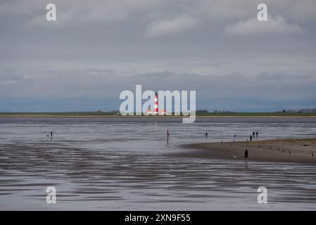 Versandzeichen für mehr als 100 Jahre. Südansicht des Leuchtturms von Westerheversand vom Strand von Sankt-Peter-Ording bei Ebbe aus gesehen. Erbaut 1906 in den Salzmärschen des Wattenmeers bei Husum, ist es ein historisches Wahrzeichen der deutschen Nordseeküste und eine beliebte Touristenattraktion. Es liegt auf einem flachen Gebäude, nur ein paar hundert Meter von der eigentlichen Wasserlinie entfernt. Stockfoto