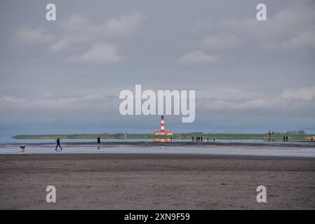 Versandzeichen für mehr als 100 Jahre. Südansicht des Leuchtturms von Westerheversand vom Strand von Sankt-Peter-Ording bei Ebbe aus gesehen. Erbaut 1906 in den Salzmärschen des Wattenmeers bei Husum, ist es ein historisches Wahrzeichen der deutschen Nordseeküste und eine beliebte Touristenattraktion. Es liegt auf einem flachen Gebäude, nur ein paar hundert Meter von der eigentlichen Wasserlinie entfernt. Stockfoto