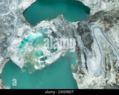 Tagebauindustrie. Kalksteinbruch mit Baggerlader und Lkw in Betrieb. Schwermaschinen im Bergbau und Baustoffversorgung. Stockfoto