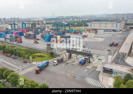 (240731) -- CHONGQING, 31. Juli 2024 (Xinhua) -- ein Luftdrohnenfoto vom 30. Juli 2024 zeigt Fahrzeuge, die Container im Trockenhafen des New International Land-Sea Trade Corridor im Chongqing International Logistics Hub Park im Shapingba District in Chongqing im Südwesten Chinas transportieren. Der Chongqing International Logistics Hub Park ist zusammen mit seinen 62 Güterzugstrecken zu einem wichtigen Drehkreuz internationaler Güterzüge in der westlichen Region des Landes geworden. Da viele internationale Logistikkanäle in Chongqing zusammenlaufen, nutzt die bergige Stadt ihre Konnektivität und Spielfreude Stockfoto