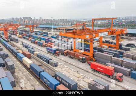 (240731) -- CHONGQING, 31. Juli 2024 (Xinhua) -- ein Luftdrohnenfoto vom 30. Juli 2024 zeigt Fahrzeuge, die Container im Tuanjiecun-Bahnhof des Chongqing International Logistics Hub Park im Shapingba-Bezirk von Chongqing, Südwest-China, transportieren. Der Chongqing International Logistics Hub Park ist zusammen mit seinen 62 Güterzugstrecken zu einem wichtigen Drehkreuz internationaler Güterzüge in der westlichen Region des Landes geworden. Da viele internationale Logistikkanäle in Chongqing zusammenlaufen, nutzt die bergige Stadt ihre Konnektivität, spielt eine strategische Schlüsselrolle und transformiert sie Stockfoto