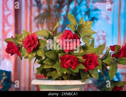 Rote künstliche Rosenblüten auf verschwommenem Hintergrund, selektiver Fokus Stockfoto
