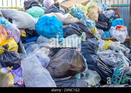 Müllkippe mit vielen schmutzigen bunten Taschen wurde lange Zeit nicht entfernt. Entsorgungsproblem Kunststoffabfall. Stockfoto