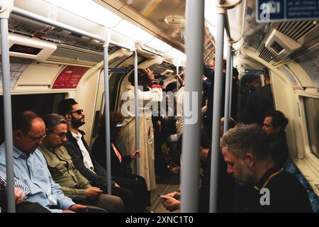 Personen, die in einem überfüllten Londoner U-Bahn-Wagen unterwegs sind. London, UK, 7. Juli 2024. Stockfoto