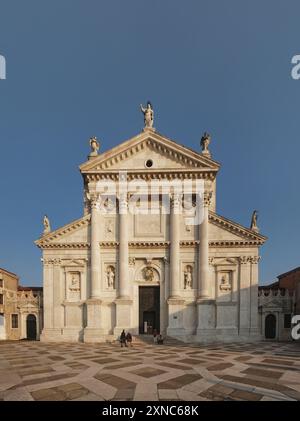 Palladio-Kirche San Giorgio Maggiore, vordere Hochfassade mit gepflasterten geometrisch gemusterten plaza Stockfoto