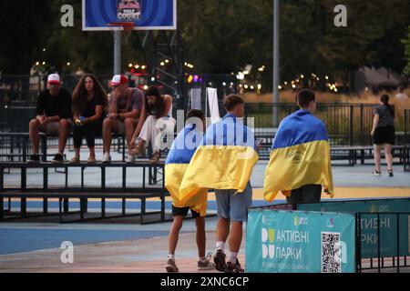 KIEW, UKRAINE - 26. JULI 2024 - drei junge Männer mit ukrainischer Flagge besuchen die Fanzone im Expocenter der Ukraine (VDNG) zur Eröffnungszeremonie der Olympischen Sommerspiele 2024 in Kiew, Hauptstadt der Ukraine. Stockfoto