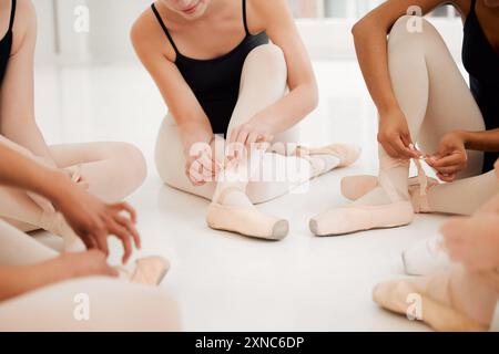 Ballett, Schuhe und Gruppe von Tänzern binden Band in Tanzstudio, Kunstakademie oder Kreativschule für Training und Training. Freunde, Künstler und Studenten Stockfoto