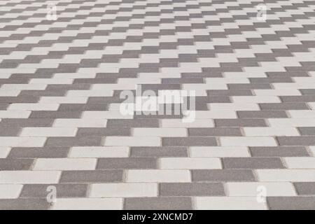 Graue Pflasterfliese, Hintergrund. Fußgängerzone in der Stadt bei Tageslicht. Stockfoto