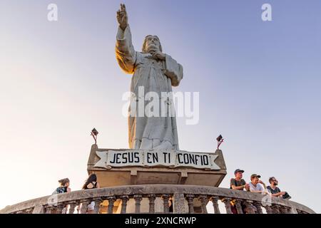 San Juan del Sur, Nicaragua - 23. März 2024: Hoch aufragende Statue des heutigen Christus der Barmherzigkeit auf einer Klippe über der Bucht von San Juan del Sur. Stockfoto
