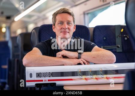 Minden, Deutschland. 31. Juli 2024. Daniel Schmeling, Deutsches Zentrum für Luft- und Raumfahrt (DLR), sitzt zusammen mit einem Modell der Deutschen Bahn in einem Versuchswagen, in dem DLR und Deutsche Bahn Aerodynamik und Strömungstechnik testen. Das Deutsche Zentrum für Luft- und Raumfahrt (DLR) Göttingen erforscht Klimaanlagen für Züge in einem Versuchswagen der Deutschen Bahn. Quelle: Guido Kirchner/dpa/Alamy Live News Stockfoto