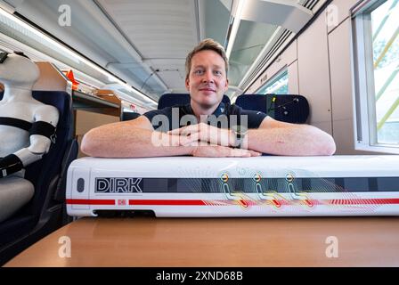 Minden, Deutschland. 31. Juli 2024. Daniel Schmeling, Deutsches Zentrum für Luft- und Raumfahrt (DLR), sitzt zusammen mit einem Modell der Deutschen Bahn in einem Versuchswagen, in dem DLR und Deutsche Bahn Aerodynamik und Strömungstechnik testen. Das Deutsche Zentrum für Luft- und Raumfahrt (DLR) Göttingen erforscht Klimaanlagen für Züge in einem Versuchswagen der Deutschen Bahn. Quelle: Guido Kirchner/dpa/Alamy Live News Stockfoto