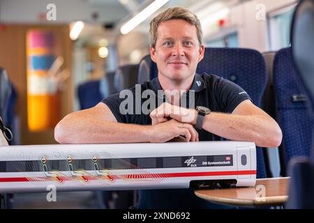 Minden, Deutschland. 31. Juli 2024. Daniel Schmeling, Deutsches Zentrum für Luft- und Raumfahrt (DLR), sitzt zusammen mit einem Modell der Deutschen Bahn in einem Versuchswagen, in dem DLR und Deutsche Bahn Aerodynamik und Strömungstechnik testen. Das Deutsche Zentrum für Luft- und Raumfahrt (DLR) Göttingen erforscht Klimaanlagen für Züge in einem Versuchswagen der Deutschen Bahn. Quelle: Guido Kirchner/dpa/Alamy Live News Stockfoto