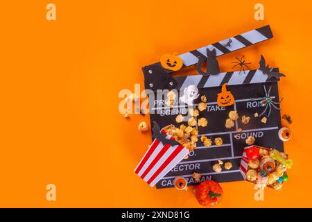 Horrorfilm, Filmabend, Halloween-Kinoparty mit Süßwareneimer, Popcorn, Filmklapperbrett und Halloween-Dekorationen Stockfoto