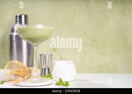 Cremiger Matcha-Martini-Cocktail Matchatini, trendiger kalter Sommercocktail. Matcha alkoholfreier Mocktail oder Alkohol Cocktail, in Martini Gläsern mit GREE Stockfoto