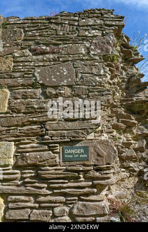 Der Rest ist die Ruine der Baumauer der Balmerino Abbey in Fife, mit einem Schild, das die Öffentlichkeit auffordert, die Mauern auf dem Gelände fernzuhalten. Stockfoto