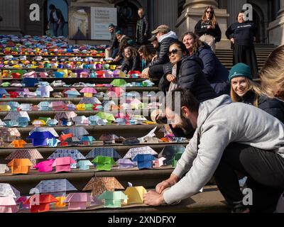 Melbourne, Australien. 31. Juli 2024. Nach dem Ende der Veranstaltung Rollen Freiwillige die Reihen der Origami-Häuser auf. 6.000 Origami-Häuser wurden vom Victorian Homeless Network auf den Stufen des Parlamentsgebäudes von Victoria platziert und symbolisieren 10 % der Sozialwohnungen, die im Staat benötigt werden, um die Obdachlosigkeit zu beenden. Quelle: SOPA Images Limited/Alamy Live News Stockfoto