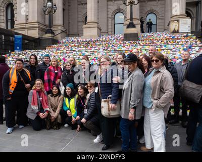 Melbourne, Australien. 31. Juli 2024. Freiwillige aus verschiedenen Obdachlosendiensten in Victoria posieren während der Veranstaltung für Fotos. 6.000 Origami-Häuser wurden vom Victorian Homeless Network auf den Stufen des Parlamentsgebäudes von Victoria platziert und symbolisieren 10 % der Sozialwohnungen, die im Staat benötigt werden, um die Obdachlosigkeit zu beenden. Quelle: SOPA Images Limited/Alamy Live News Stockfoto