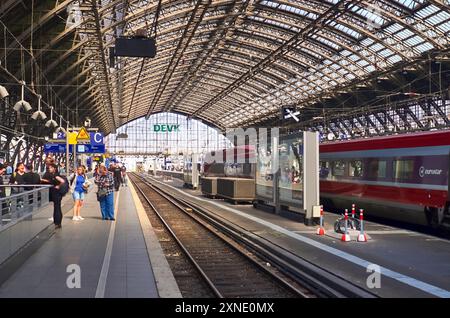 Köln, Deutschland - 30. Juli 2024: Innenansicht des Kölner Hauptbahnhofs mit Zügen und Fahrgästen Stockfoto