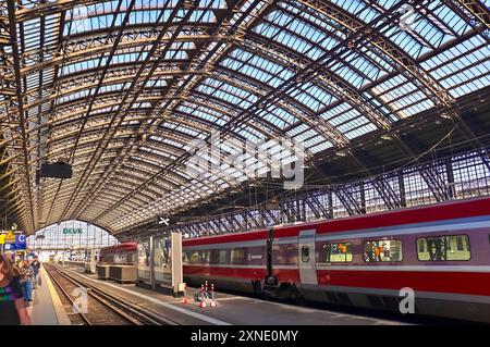 Köln, Deutschland - 30. Juli 2024: Innenansicht des Kölner Hauptbahnhofs mit Zügen und Fahrgästen Stockfoto