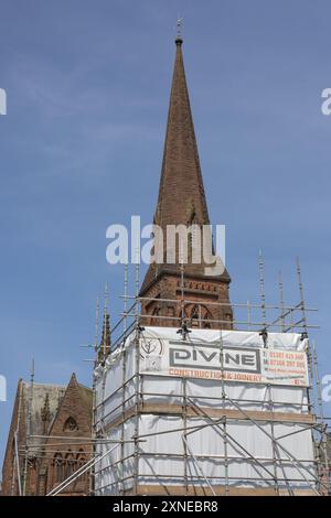 Sehen Sie in vertikaler Form Reinigungs- und Wartungsarbeiten an der Statue von Robert Burns in Dumfries, Schottland. Turm der Greyfriars Church dahinter. Stockfoto