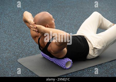 Auslösepunkt für Rückenmassage mit Schaumstoffrolle. Myofasziale Freisetzung. Stockfoto