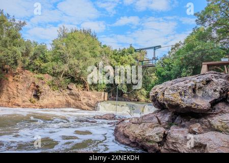 Blick auf einen Hennops Wander Trail, mit Fluss, kleiner Brücke und Seilbahn über den Fluss, Hartbeespoort, Johannesburg, Südafrika Stockfoto