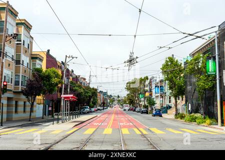 In der Church Street befinden sich die Muni Metro Stadtbahnen, Trolley-Linien und urbane Architektur. Bäume säumen die Bürgersteige und eine spezielle rote Busspur Stockfoto