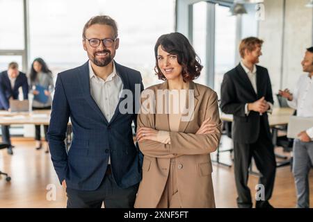 Geschäftsleute, die in einem modernen Büroumfeld selbstbewusst lächeln Stockfoto