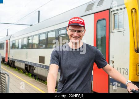 Herentals, Provinz Antwerpen, Belgien - 10. Juli 2024 - 45 Mann mit rotem Hut am Bahnhof. Modell freigegeben Stockfoto