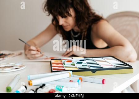 Frau zeichnet mit Aquarellen. Stockfoto