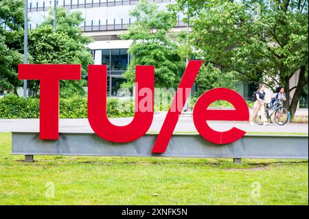 Eindhoven, Nord-Brabant, Niederlande, 10. Juli 2024 – Studentinnen, die am Zeichen der Technischen Universität Eindhoven tue vorbeikommen Stockfoto