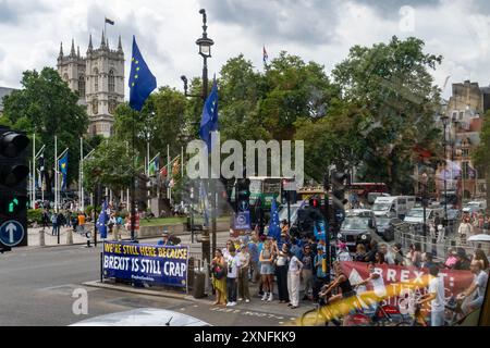 London, Großbritannien - 24. Juli 2024: Brexit-Protestschild besagt: „Brexit is still crap“ in der Nähe des Parliament Square, fotografiert durch ein Busfenster mit Reflexionen. Stockfoto