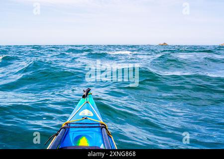 Ein Seekajak in den Gezeitenrennen von Rhoscolyn Beacon vor Anglesey, Nordwales Stockfoto