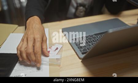 Die Hand einer Frau in einem Detektivbüro mit Hinweisen, einschließlich eines blutigen Fingerabdrucks, deutet auf eine Untersuchung hin. Stockfoto