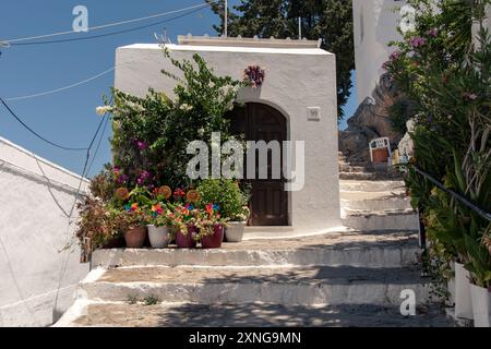 Wunderschönes kleines traditionelles griechisches Haus mit vielen Pflanztöpfen in Lindos, auf der griechischen Insel Rhodos Stockfoto