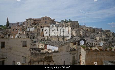 Panoramablick auf die historische Stadt matera in basilicata, italien, mit dicht gebauten Steinhäusern unter blauem Himmel. Stockfoto