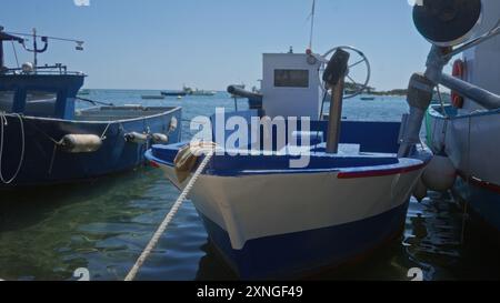 Fischerboote in porto cesareo, italien, die die ruhige Küstenatmosphäre von salento, apulien an einem klaren, sonnigen Tag mit traditionellen Schiffen und c einfangen Stockfoto