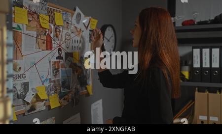 Eine rothaarige Frau untersucht Verbrechen im Büro des Detektivs und analysiert Hinweise an Bord. Stockfoto