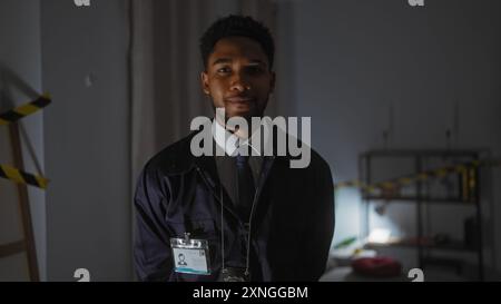 Ein afroamerikanischer Detektiv in einem Tatortuntersuchungsraum sieht ernst und professionell aus. Stockfoto