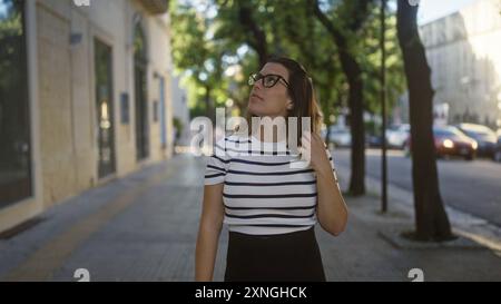 Eine schöne junge hispanische Frau mit Brille geht nachdenklich durch die Straßen von lecce, apulien, italien, an einem sonnigen Tag. Stockfoto