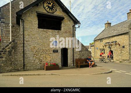 Das historische Rathaus und die Uhr und das Old Swan Inn mit Radfahrern, Llantwit Major, Vale of Glamorgan, Südwales. Vom Juli 2024. Sommer Stockfoto