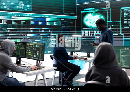 Hacker aus der Regierung, die fortschrittliche Software zum Schutz vor Cyberbedrohungen einsetzen, arbeiten im Team. Spezialisten für Cybersicherheit, Daten- und Netzwerkschutz vereinen Kräfte in High-Tech-Büros. Stockfoto