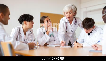 Ältere weibliche Professorin für Medizin, die Vortrag an die Gruppe von Praktikumsärzten hält Stockfoto