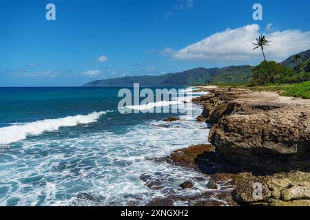 Eine malerische Klippe am Meer mit Wellen, die unter dem Himmel auf sie krachen Stockfoto